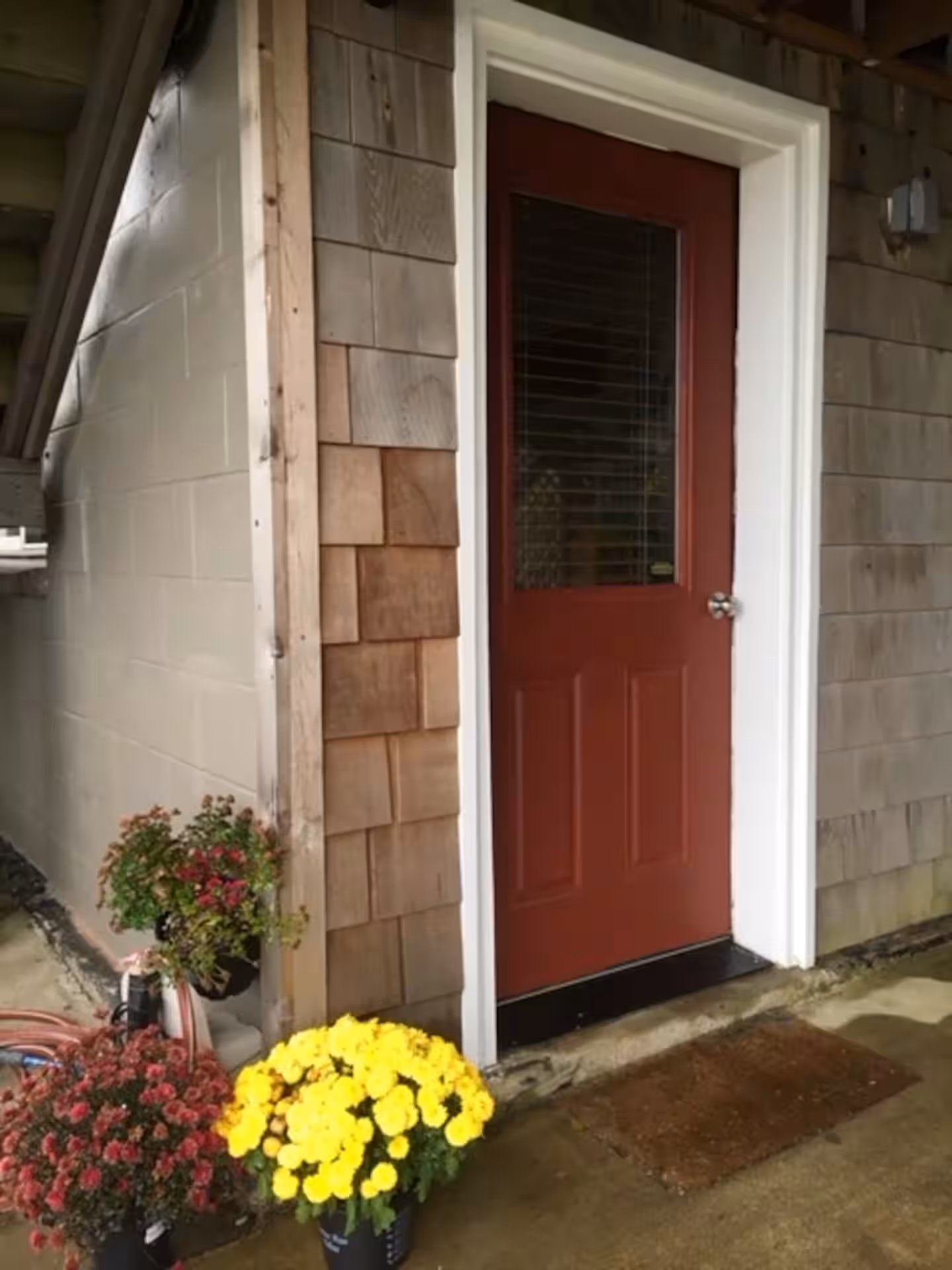 Oregon House Apartment's ground-level entrance, red door